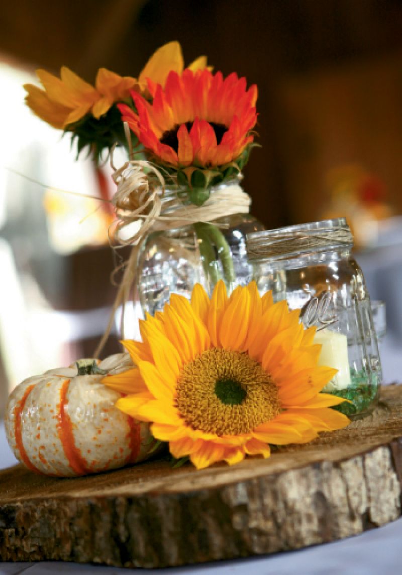 NICE SLICE: “We cut wood slabs for centerpieces, collected Mason jars for votives and vases, and arranged all the flowers,” says Rheney, explaining that about 80 percent of her and Jacob’s wedding was homemade.