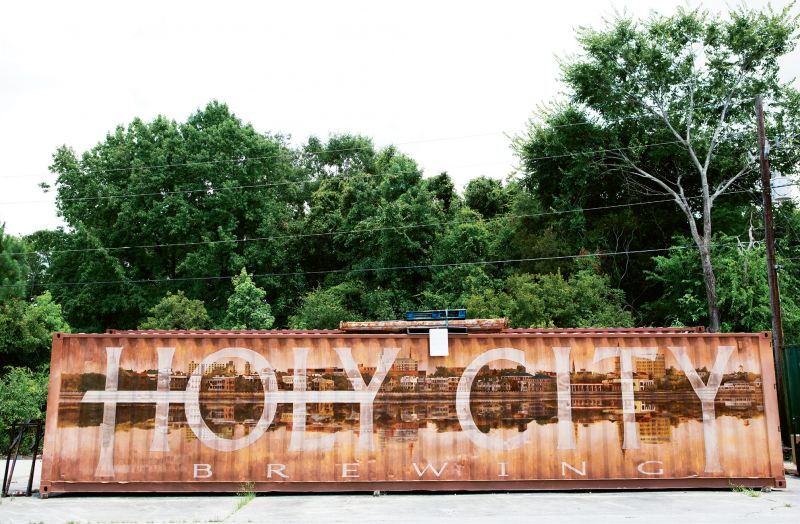 Holy City  by Sean Williams  2011  Holy City Brewing  (4155 Dorchester rd.,  North Charleston)  Holy City Brewing tapped the College of Charleston studio art grad (who had welded some of their taps and made a stencil for their kegs) to create a mural relating to Charleston and incorporating their logo on a shipping container in the brewery parking lot. Williams has also painted labels for a number of their bottled and canned beers. more recently the artist has been working on murals for Home Team BBQ&#039;s downtown and West Ashley locations.