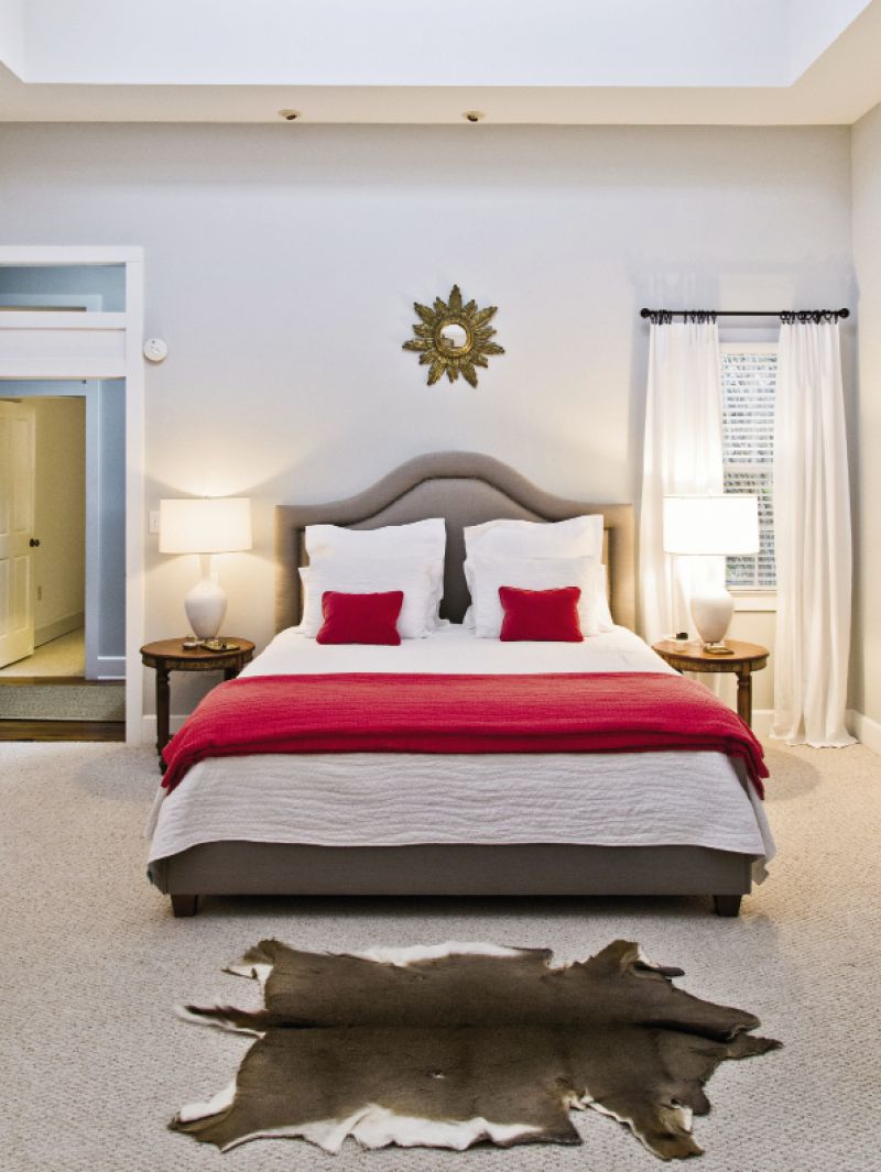 The master bedroom, furnished with a pair of lamps from Celadon, a deerskin rug from the boys’ hunting collection, and an upholstered khaki headboard from GDC.
