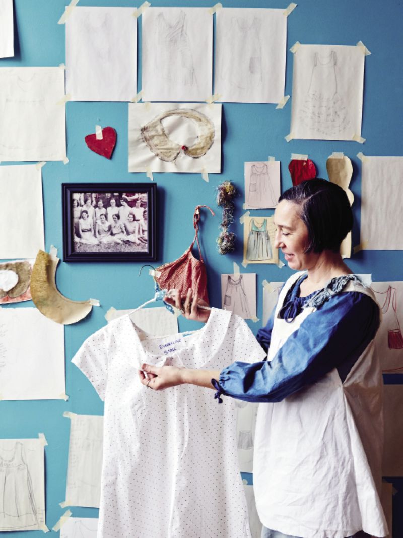 At the 701 Center for Contemporary Art, the new Madame Magar collection of muslin and canvas frocks hangs on pulleys and  hooks. As part of the exhibit, Charleston-based designer Leigh Magar has created a temporary studio workshop within the gallery space so  visitors can see her sewing, dyeing, and adding penciled lettering to the dresses.