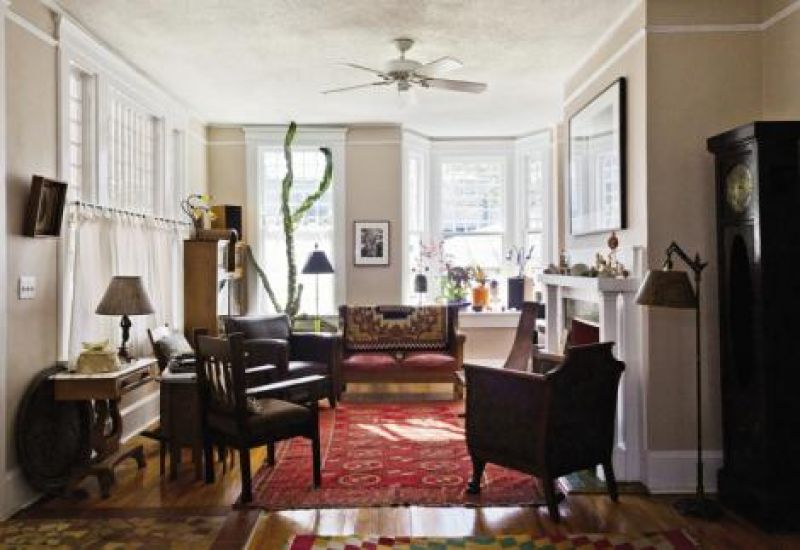 conversation peace: A Navajo blanket, Parsons bench, and 19th-century Tekke rug center the eclectic seating in the living room. A cactus suns along a back window.