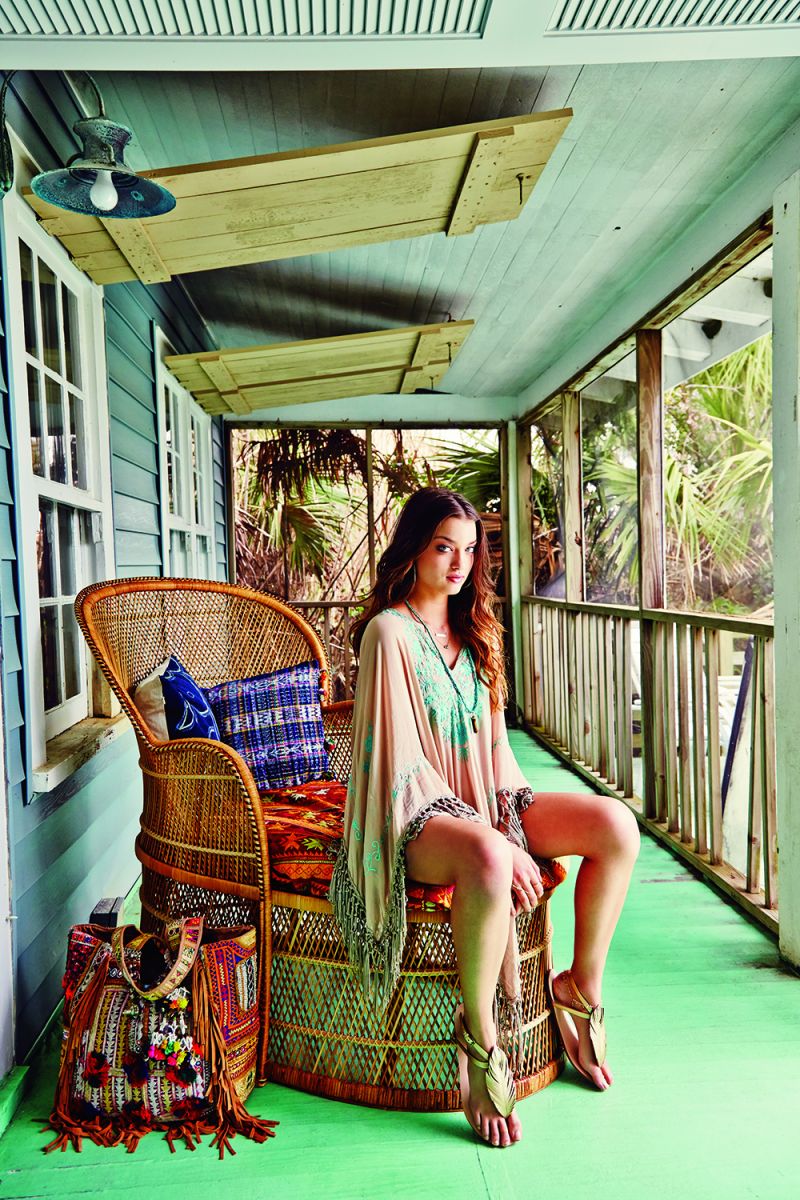 Miss June poncho, $168 at Lori + Lulu; Robin Haley gold loop earrings, $105 at Shirtini; Kate Davis “Sandbar” necklace with mother-of-pearl and 14K gold-fill plate, $92 at katedavisjewelry.com; Birdsong Design “Sleeping Beauty” turquoise cluster necklace, $45 at Birdsong Design Studio; Peyton William turquoise and tiger eye necklace, $125 at Peyton William; Corso Como “Edgar” sandals, $88 at Copper Penny Shooz; and artisan fringe tote, $295 at Calypso. Props: rattan chair from Charleston Revisions, pillows and blanket from IBU