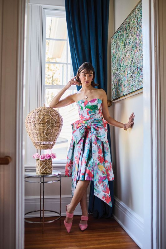 <strong>Tropical Punch:</strong> Jenan McClain “The Marlow” bustier top, $395, skirt, $595, and “Dollytta” tourmaline earrings, $350, at <a href="https://jenanmcclaindesign.com/products/dollytta-earrings-sapphire-copy" target="_blank">jenanmcclaindesign.com</a>; Jane Win mother-of-pearl “Forever Moon Face” pendant necklace, $348 at <a href="https://www.croghansjewelbox.com/products/jane-win-forever-mother-of-pearl-moon-face-pendant-necklace" target="_blank">Croghan’s Jewel Box</a>; Gemma Couture amethyst ring, $1,540 at <a href="https://pollysjewelry.com/" target="_blank">Polly’s Fine Jewelry</a>; amethyst halo diamond ring, $455 at <a href="https://diamondsdirect.com/" target="_blank">Diamonds Direct</a>; “Kiki” cuff in “Rainbow Ombre,” $108, and “Kelly” cuff in “Peridot Brandy,” $94, at <a href="https://www.jujuloves.com/products/gold-cuff-multi-colored-crystals" target="_blank">JuJuLoves.com</a>; Manolo Blahnik “Circeamu” suede mules, $975 at <a href="https://www.rtwcharleston.com/" target="_blank">RTW</a> - (Prop) “Provence” rattan hot air balloon, $425 at <a href="https://www.juliska.com/products/provence-hot-air-balloon-large?variant=40326784811097" target="_blank">Juliska</a>