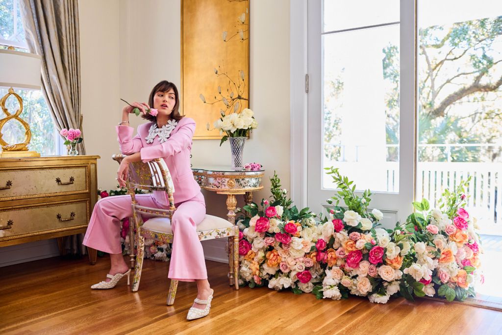 <strong>Rosy Prospects:</strong> Maria McManus “Shrunken” stretch wool jacket and mid-rise flare pants in “Cherry Blossom Pink,” $1,290 and $750 at <a href="https://www.rtwcharleston.com/" target="_blank">RTW</a>; Jahde “Floral Queen” collar in white, $475 at <a href="https://jahdemade.com/collections/the-floral-collar/products/floral-collar?variant=40191889211495" target="_blank">Jahde Leather Atelier</a>; Ryan Gems emerald-cut aquamarine and diamond ring, $3,950, DSL Pearl freshwater pearl and diamond bracelet, $3,630, and DSL Pearl freshwater pearl and diamond ring, $3,550, at <a href="https://diamondsdirect.com/" target="_blank">Diamonds Direct</a>; Azalea Wang “Enya Pearl” dress mules, $119 at <a href="https://www.dillards.com/p/azalea-wang-enya-pearl-embellished-dress-mules/519437802" target="_blank">Dillard’s</a> - (Props) Grounded floral arch from <a href="https://www.weddingflowersforrent.com/collections/garlands/products/grounded-floral-arch-regular" target="_blank">Wedding Flowers For Rent</a>