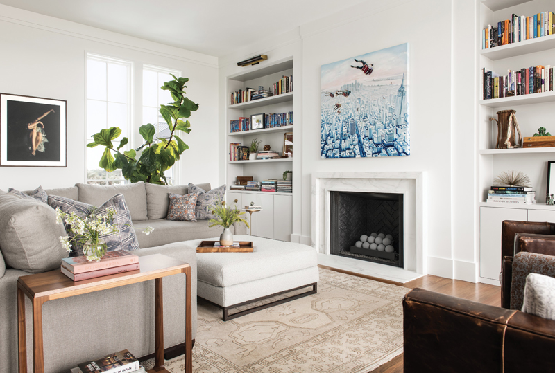 Laid-Back Living: The layout of the main living space is almost identical to their previous house, taking full advantage of the gorgeous sunset views over the Ashley River. Melissa kept the sofa and leather chairs and added a custom-designed Calacatta marble fireplace surround, complemented by artwork the couple acquired in Germany.