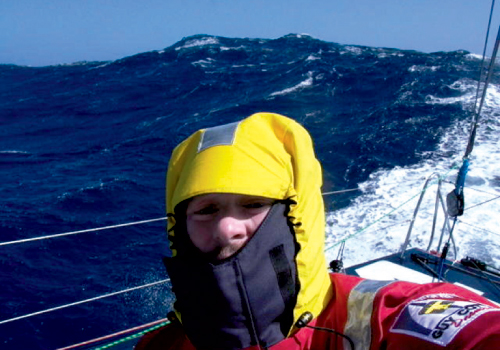 Brad braves rough seas in full offshore weather gear, including harnesses to strap himself to the boat.